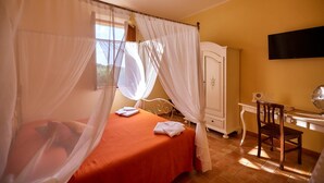 A bedroom with a bed, a desk, and a wardrobe. - Agriturismo Podere Casa al Vento (Montepulciano)