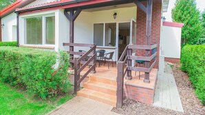 A house with a covered porch, a brick exterior, and a tiled patio. - Imperiall Resort & MediSpa - Cottage (Ustronie Morskie)