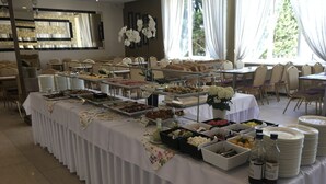 A buffet setup with various food items and beverages, arranged on tables covered with white tablecloths. - Imperiall Resort & MediSpa - Cottage (Ustronie Morskie)