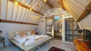 A cozy bedroom with a wooden bed, a mirror, and a view of a balcony.