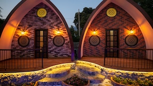 A building with two arched brick structures, each with a door and a circular window.