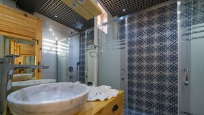 A modern bathroom with a large marble sink, wooden vanity, and patterned tiles.