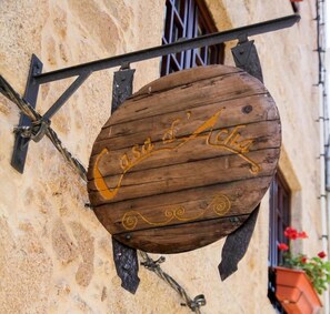 A wooden sign with the inscription "Casa d'Acqua" mounted on a building.
