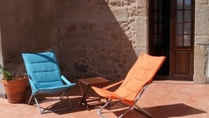 A patio with two lounge chairs, a small table, and a potted plant. - Casa d'Acha (Idanha-a-Nova)