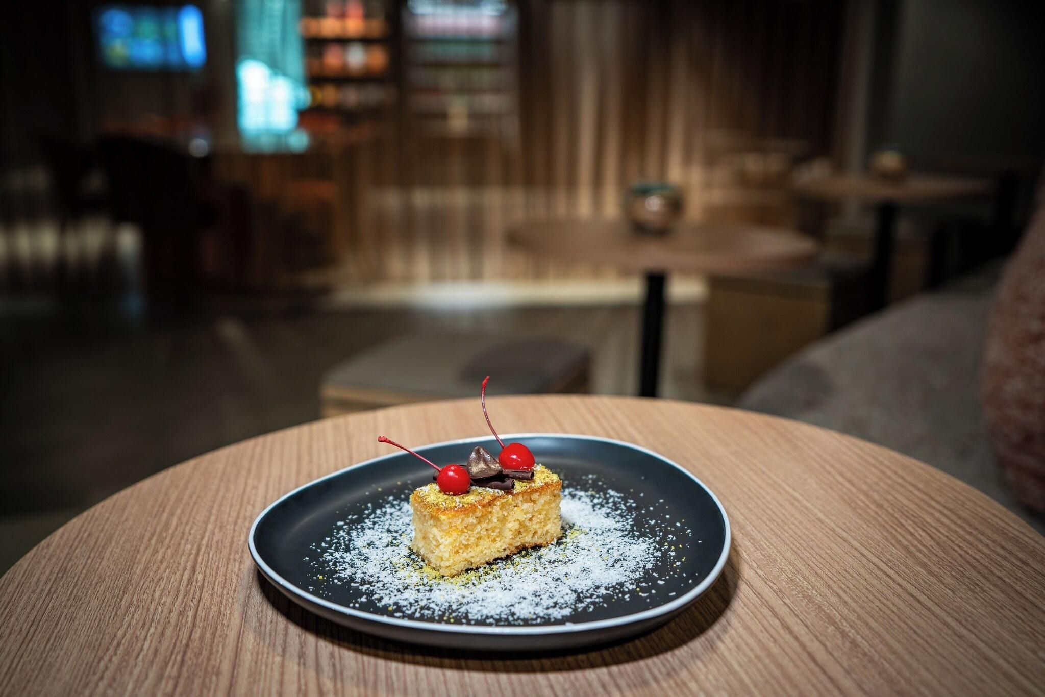 A dessert on a plate with a blurred background of a room.