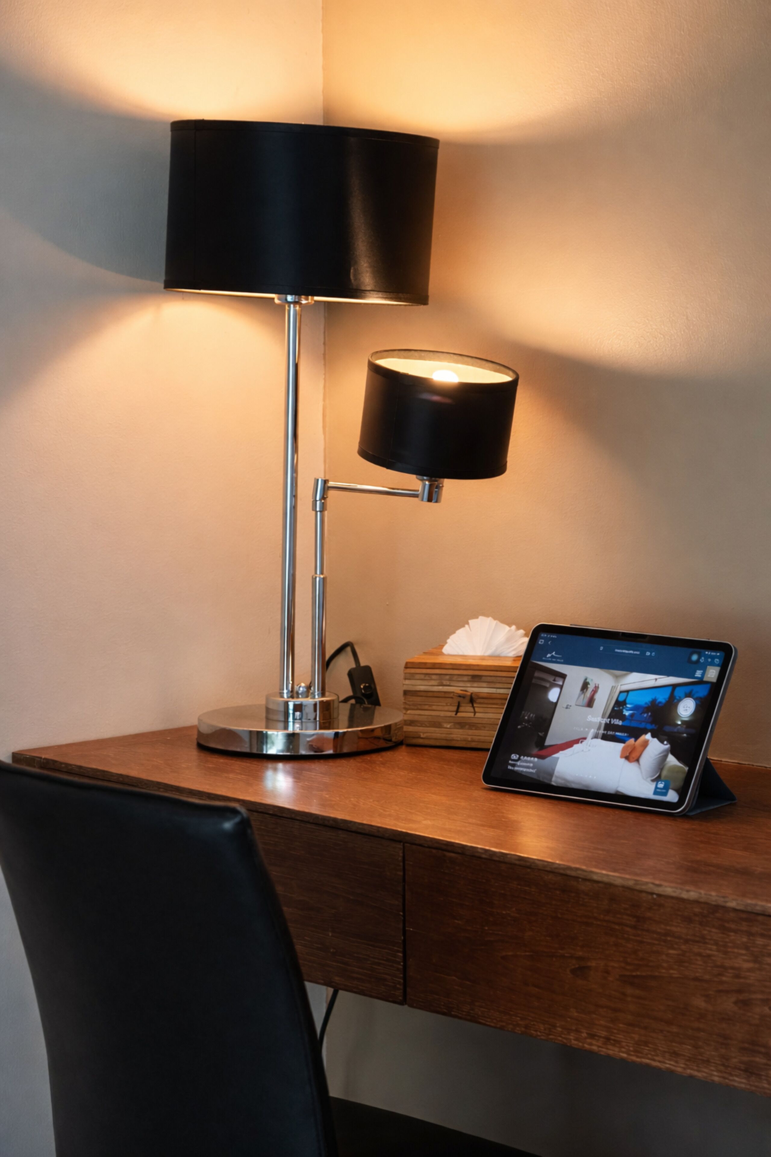 A desk with a lamp, a tablet, and a tissue box.