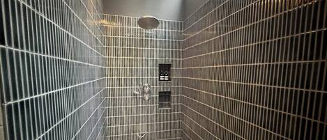 Un baño pequeño con azulejos, un tragaluz, ducha y retrete.