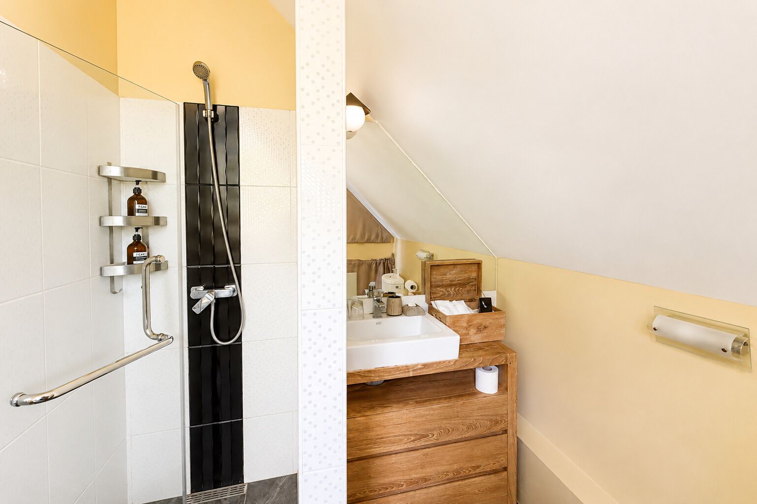 Une salle de bain avec une douche, un lavabo et un meuble-lavabo en bois.