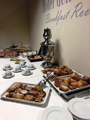 A breakfast buffet with various pastries, a coffee machine, and tea cups. - Hotel delle Rose (Cascia)