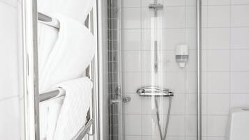 Un baño moderno con cabina de ducha de vidrio, un perchero con toallas blancas y un dispensador de jabón en la pared.