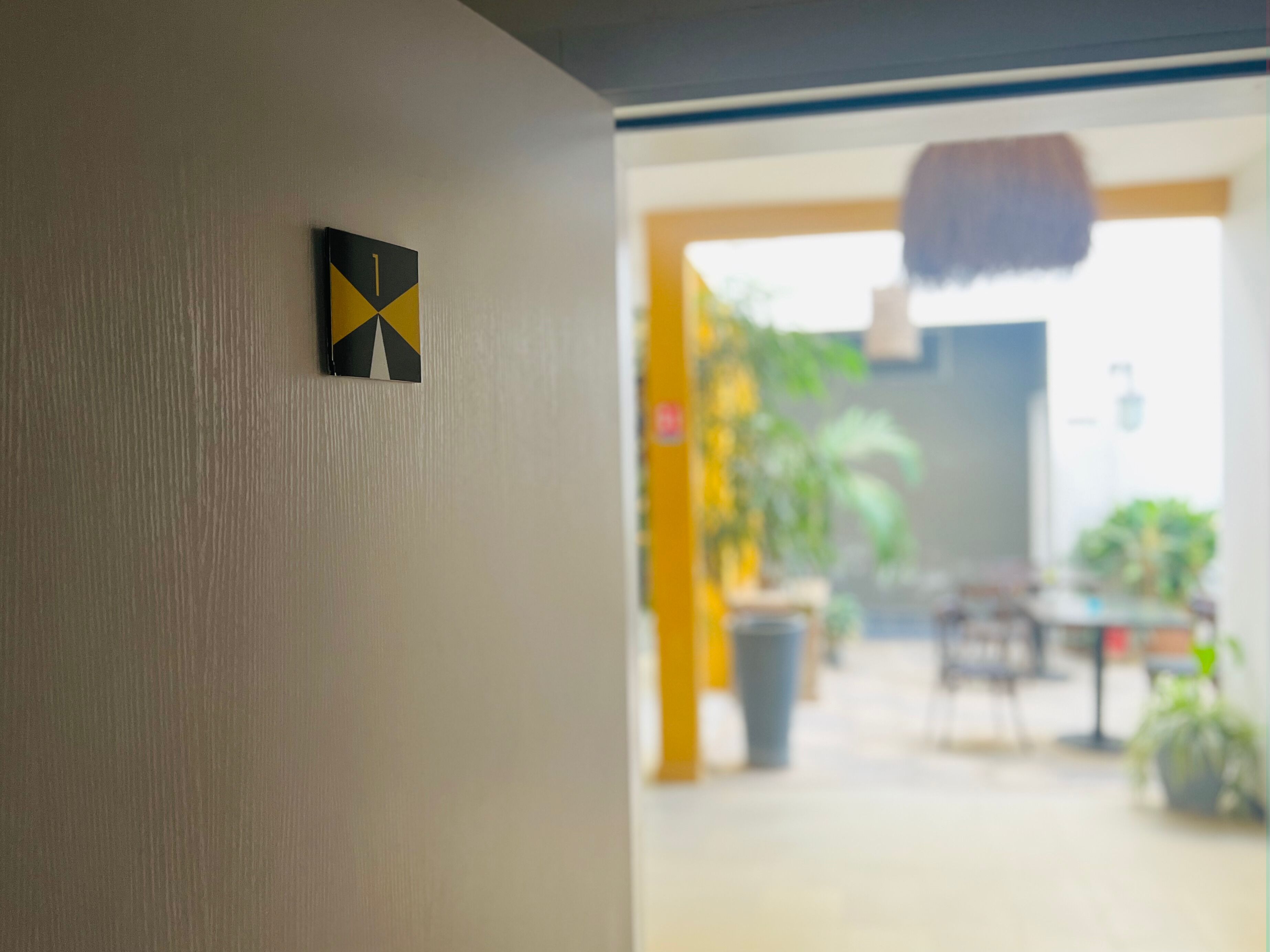 A hallway with a door leading to a room.