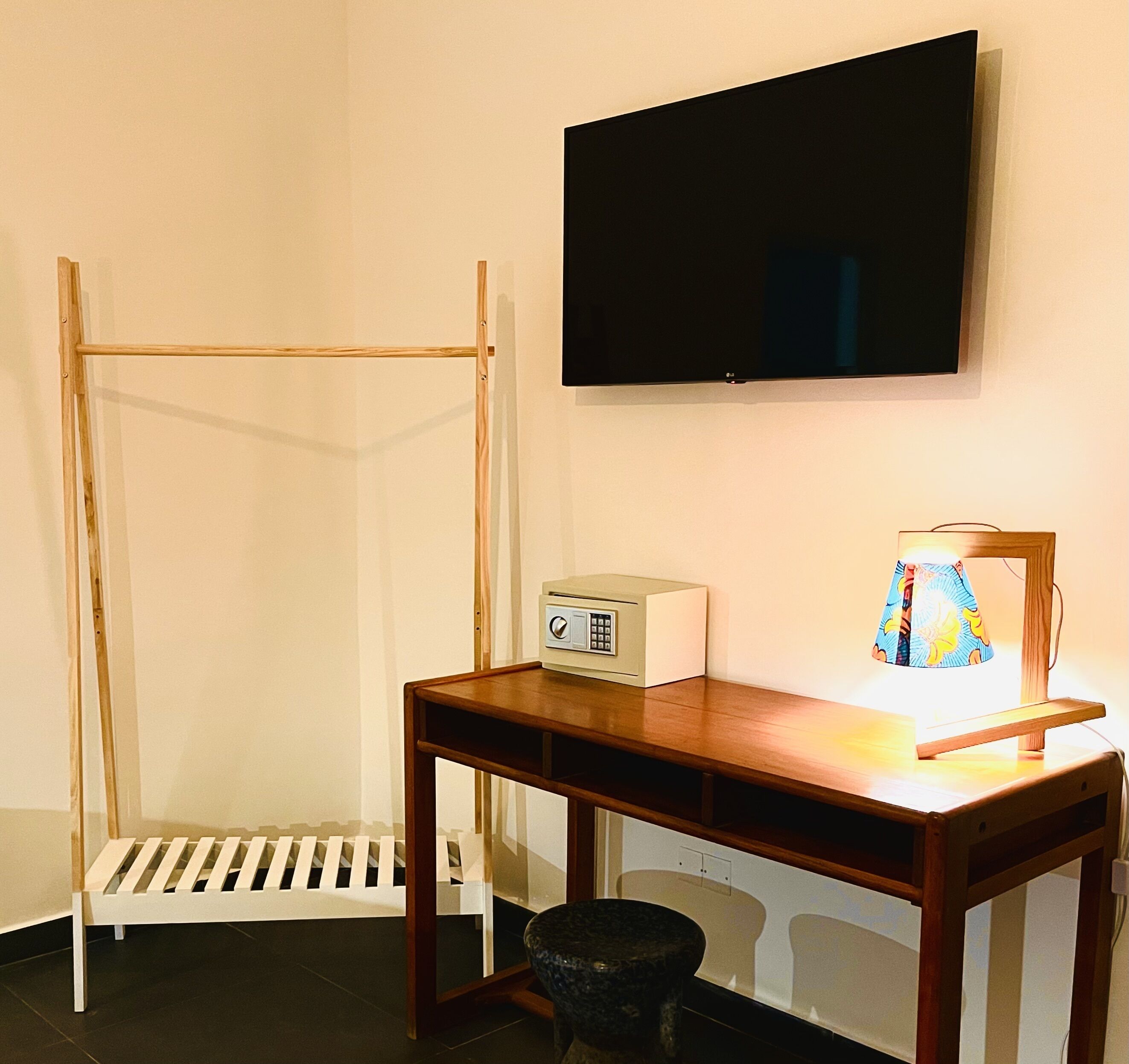 A room with a bed, a desk, a television, and a lamp.