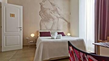 Ein Hotelzimmer mit einem Bett, einem Wandbild, einem Nachttisch mit Lampe und einer Tür mit der Aufschrift 'Room 1'.