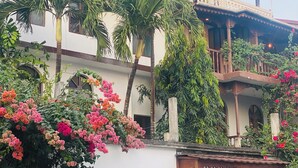 A multi-story building with a traditional architectural style, featuring balconies and a covered upper level. - Garden Lodge (Zanzibar Town)