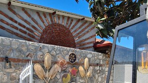 A stone wall with decorative fans and a metal gate. - Ilkiz Beach Hotel (Fethiye)
