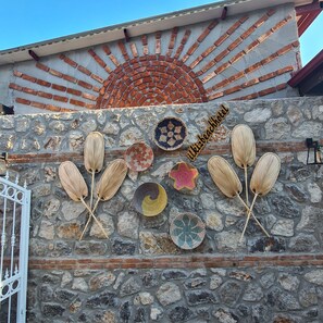 A stone wall with decorative plates and woven fans. - Ilkiz Beach Hotel (Fethiye)
