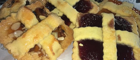 A plate of fruit tarts with a lattice crust on a white doily.