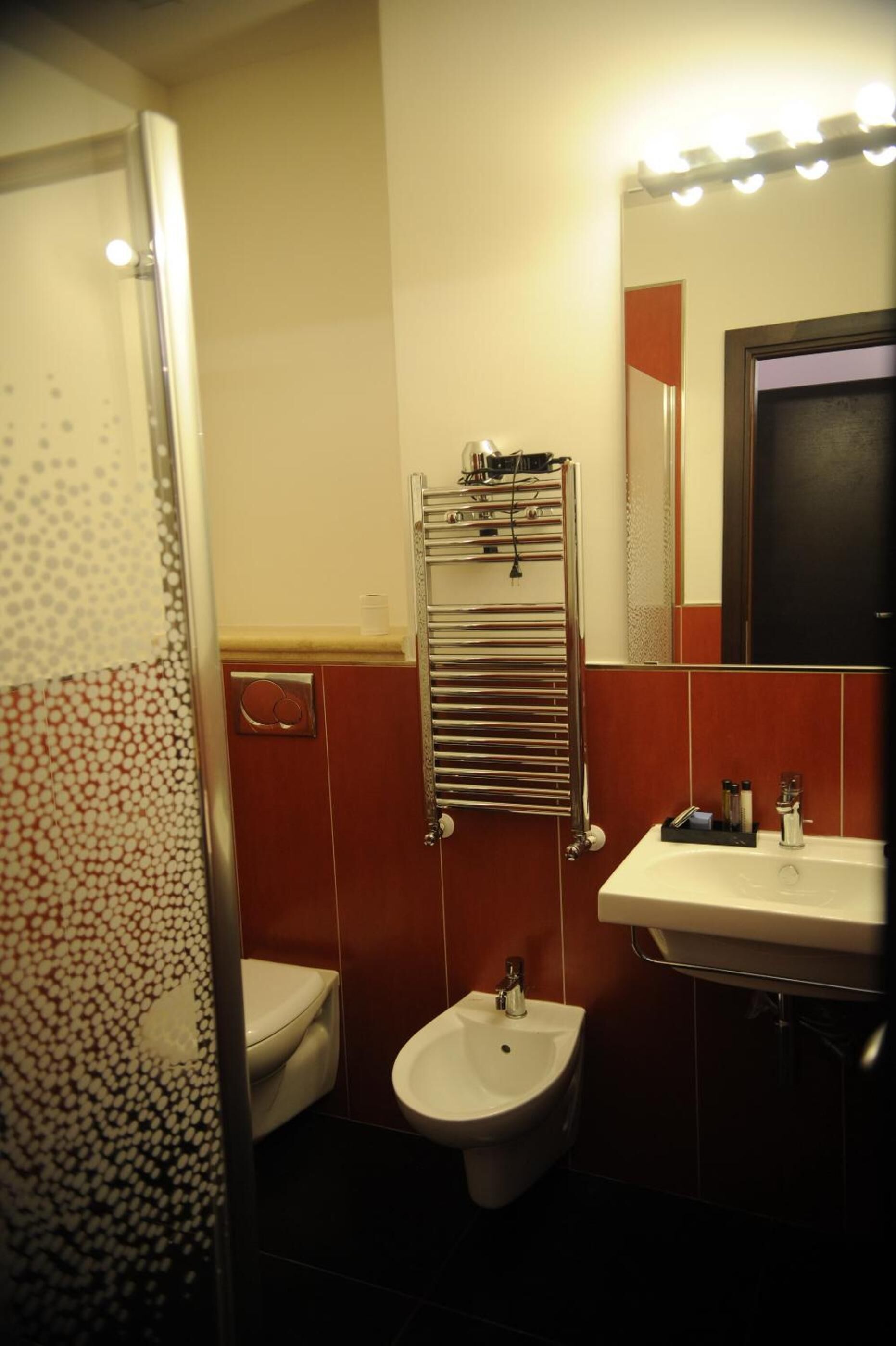 A bathroom with a toilet, bidet, and a sink.