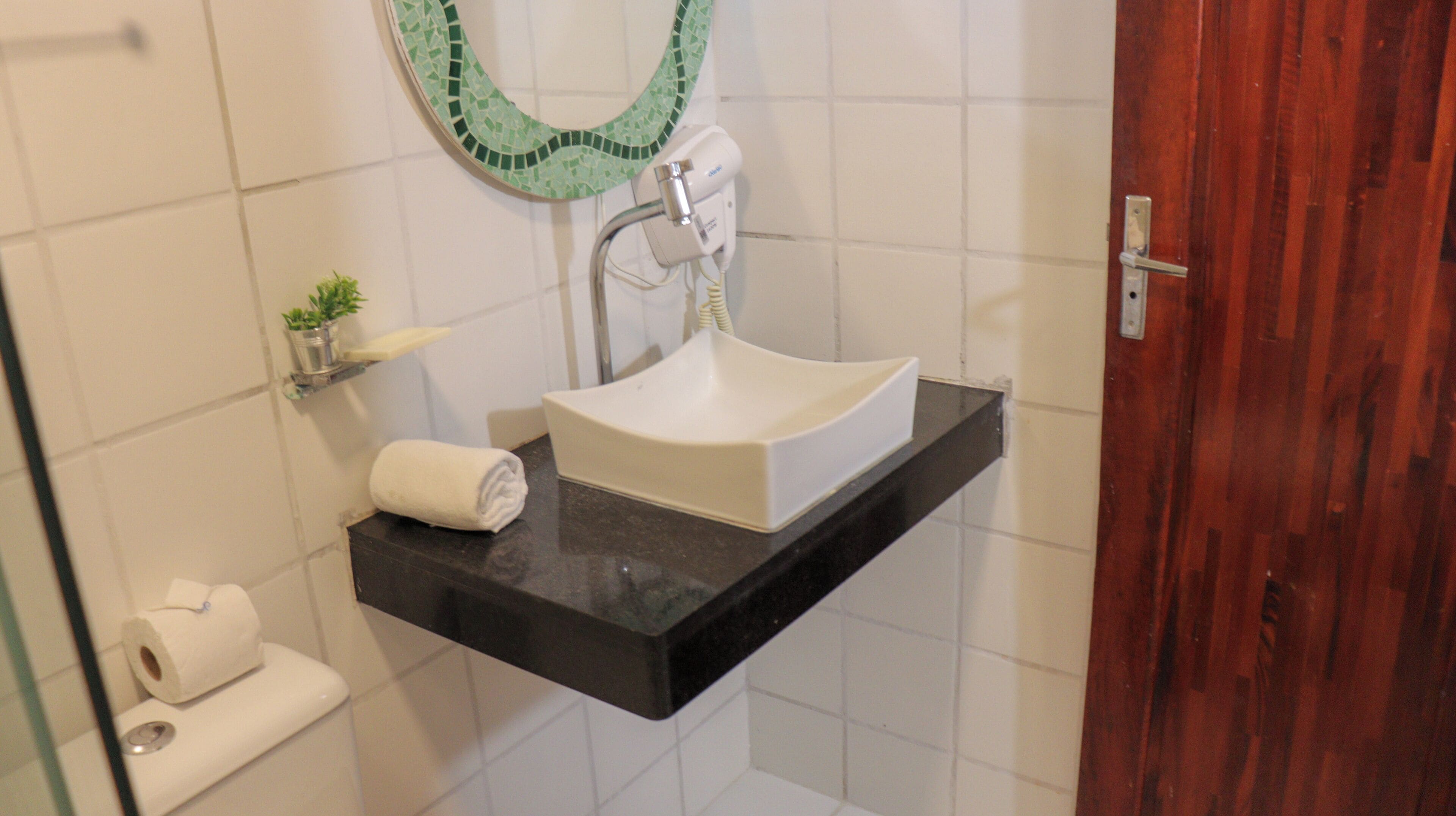 A bathroom with a white sink, a toilet, and a shower area.