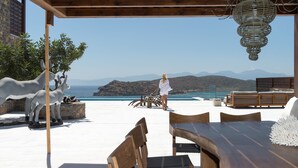 A covered outdoor seating area with a view of the sea and mountains. - Villa Dimitra by Elounda Island View Villas (Agios Nikolaos)