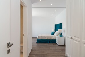 A bedroom with a bed, nightstand, and a door leading to a bathroom.