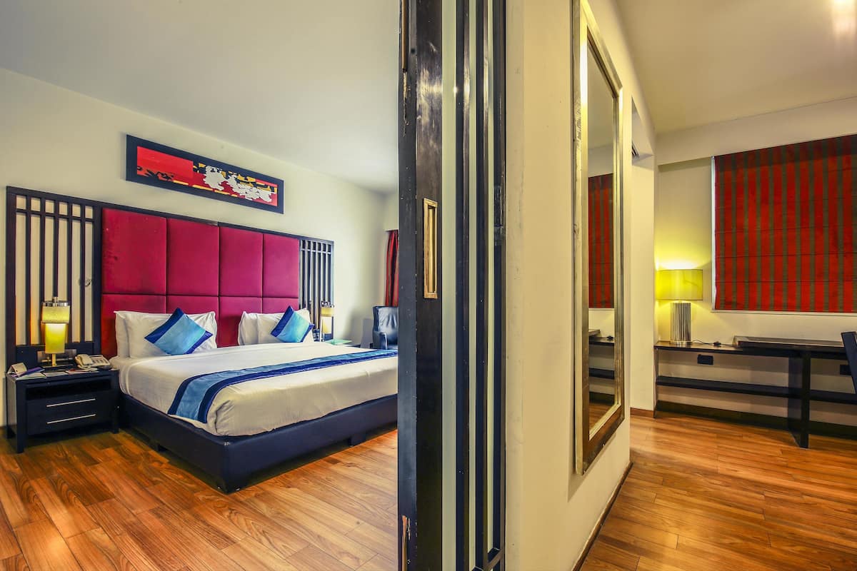 Ein Hotelzimmer mit einem großen Bett, einem Schreibtisch und einem Spiegel.