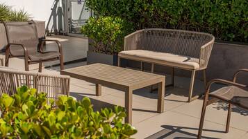 An outdoor patio with a sofa, chairs, and a table.