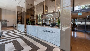 Un comptoir d’accueil moderne au design en marbre, portant le nom « LAGHETTOStilo ».
