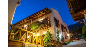 A building with a wooden balcony, a sign reading "WHITEHOUSE," and a mountain in the background. - Courtyard Hotel Kalkan (Kas)