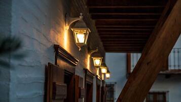 A building with a wooden beam structure and wall-mounted light fixtures.