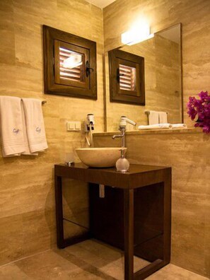 Une salle de bain avec un meuble-lavabo en bois, un grand miroir et deux porte-serviettes.