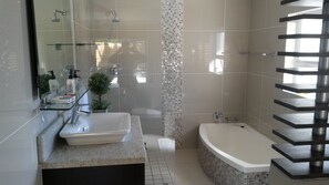 Relax in a spacious bathroom with a bathtub and granite sink.