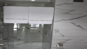 A bathroom with a glass shower enclosure, marble walls, and two white towels hanging on a rack. - Reda Palas Karanfil (Ankara)