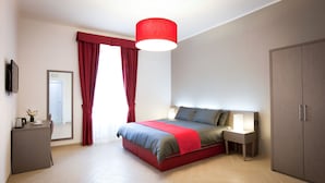 A modern bedroom with a bed, bedside table, wardrobe, and a desk with a chair. - Castellani a San Pietro (Rome)