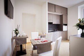 A modern kitchen with grey cabinets, a black backsplash, and a built-in oven.