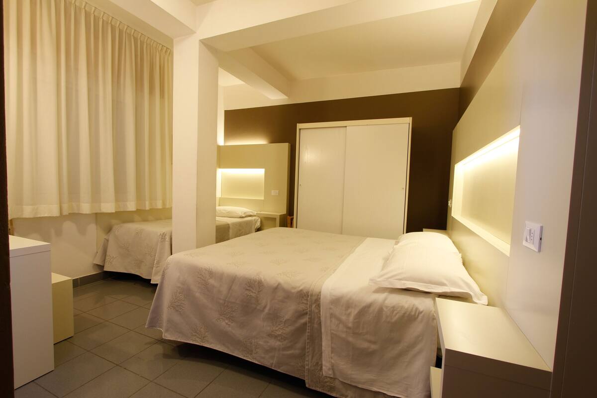 Une chambre d’hôtel comprenant un lit, des tables de chevet, une armoire et une salle de bain.