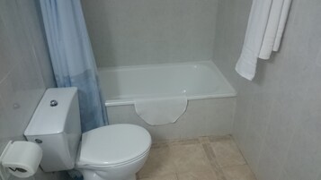 Un baño pequeño con inodoro, lavamanos y bañera.