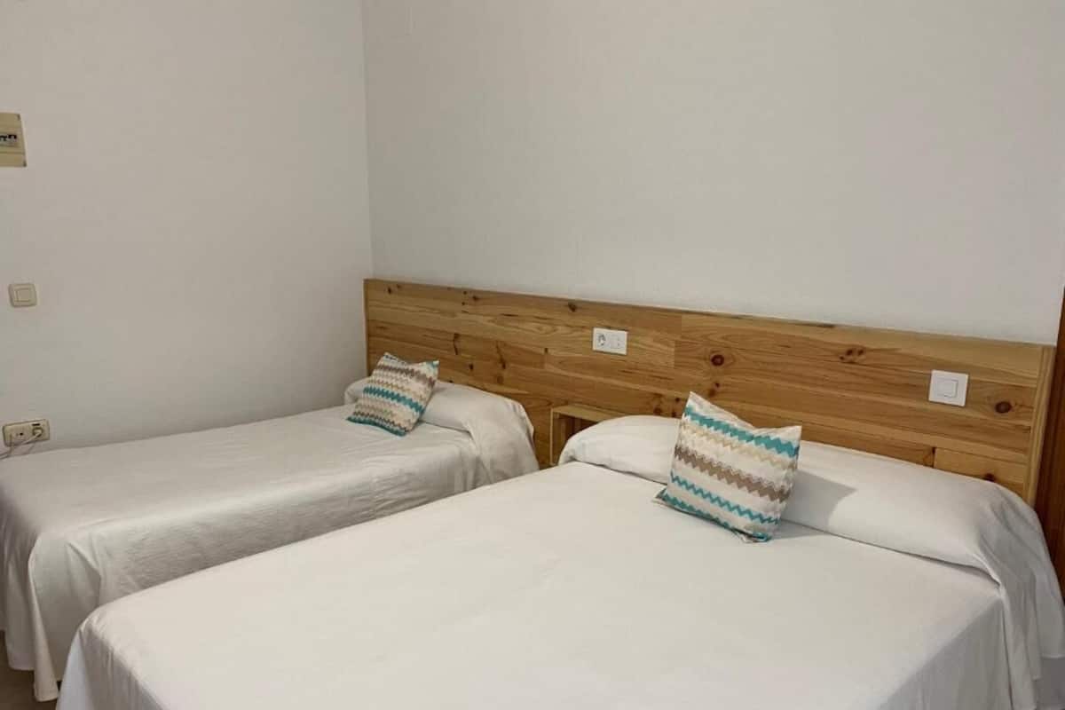 Two single beds with wooden headboards and white bedding.