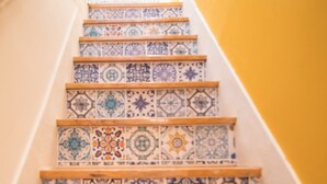 Un escalier avec des carreaux décoratifs et des marches en bois.