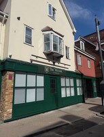 Un edificio con fachada verde, un letrero que dice 'The Manor at Orpington' y un diseño de ventanas tradicional.