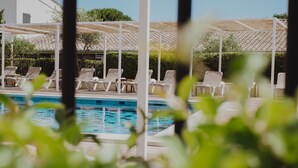Un espace piscine doté de chaises longues et d’une pergola.