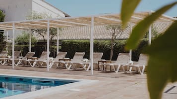 Piscine extérieure, parasols de plage, chaises longues