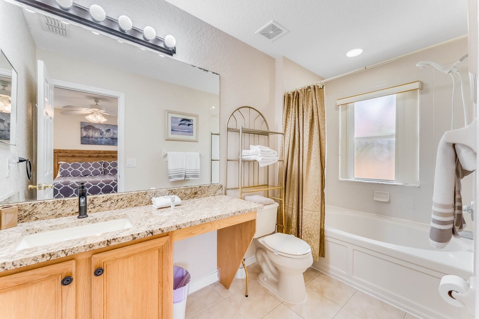 Une salle de bain avec un comptoir en marbre, des toilettes, une baignoire et une douche.