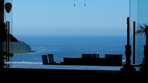 A room with a view of the ocean, a chair, a table, and a decorative vase. -  CASA MONARCA. Self sustained house in La Ropa, Zihuatanejo, Gro. México. (Zihuatanejo)