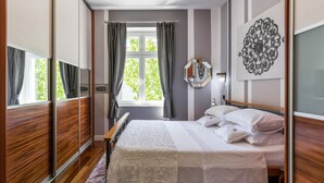 A bedroom with a bed, a window with curtains, a mirror, and a wall art piece. - UNIQUE & URBAN 4* House DelMarco apt @ TOP CENTRAL LOCATION (Split)