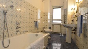 Un baño con bañera, inodoro y lavamanos.