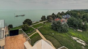 A view of a lake with boats, a park with pathways, and buildings with red roofs. - Galerius Panorama Beach - D Apartman (Siófok)