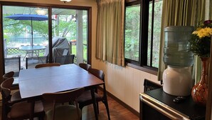 Un comedor con una mesa y sillas, un ventilador de techo y un dispensador de agua.