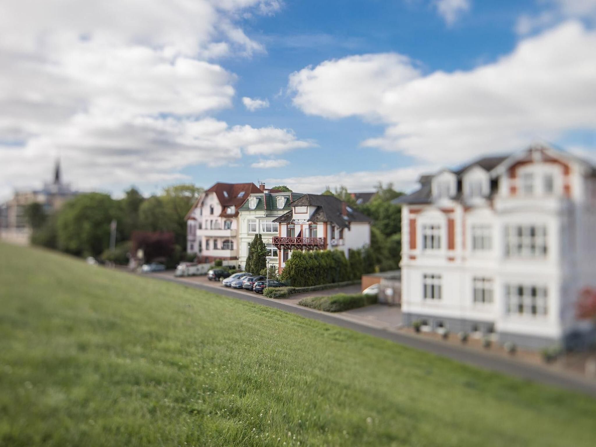 Un modelo de una zona residencial con casas, una calle y un campo cubierto de césped.