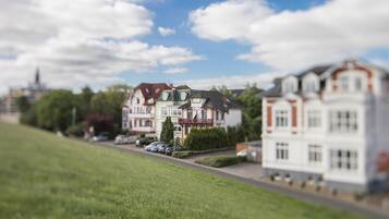 Une maquette représentant un quartier résidentiel avec des maisons, une route et un champ d’herbe.